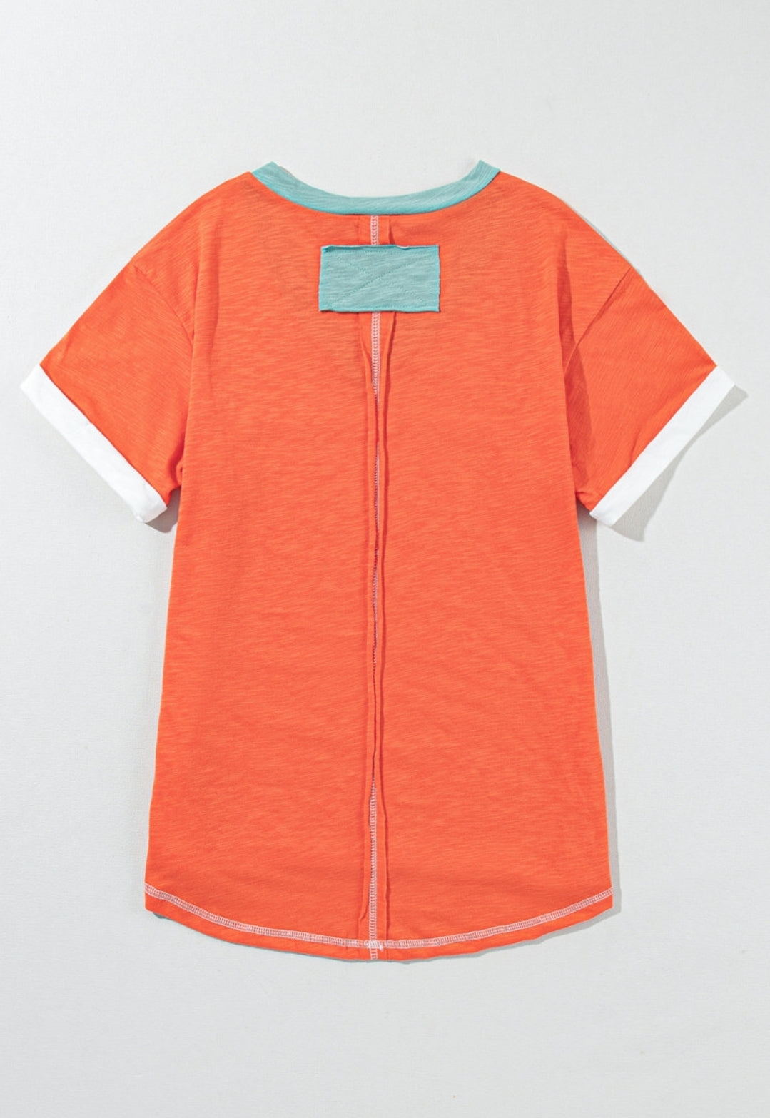 Orange tee with aqua trim around v-neck & exposed seams